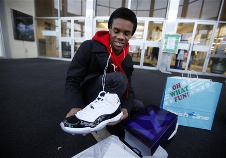 Kristopher Rush, 14, shows off the Nike Air Jordan shoes he got for Christmas from his parents Friday, Dec. 23, 2011, outside the Lafayette Square Mall in Indianapolis, where he waited in line with his father and brother for over three hours. Police were called in to control crowds of shoppers flocking Lafayette Square and Castleton Square malls in Indianapolis to control the crowds waiting for the shoes. The release of Nike's retro Air Jordans caused a frenzy at stores across the nation early Friday, with hundreds of people lining up for a chance to buy the classic basketball shoes and rowdy crowds breaking down doors and starting fights in at least two cities. AP Photo/The Indianapolis Star, Danese Kenon)  NO SALES